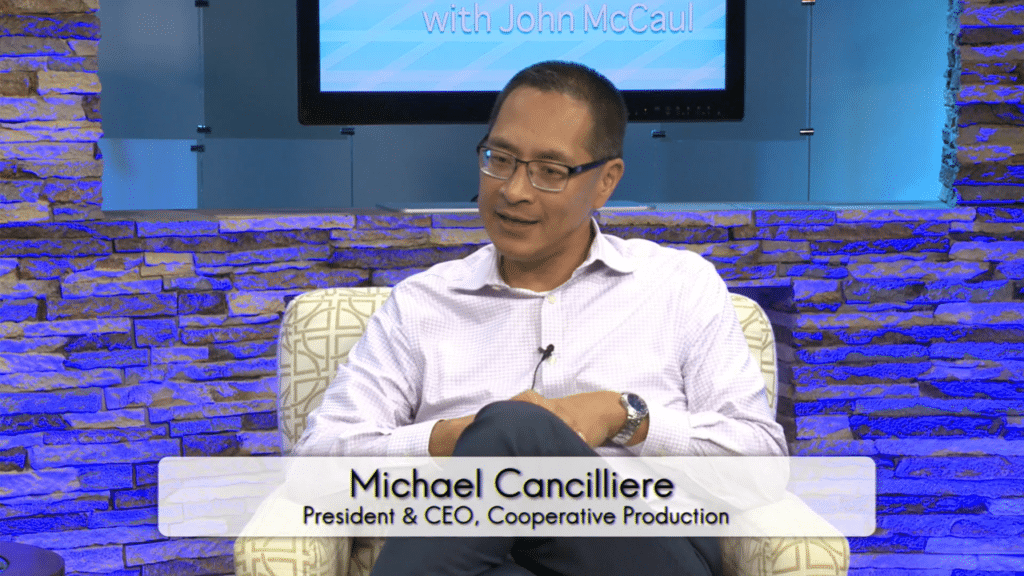 Photo of a man in a white shirt with glasses sitting in a comfortable chair